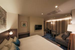 大阪市にあるホテルコード 心斎橋のベッドとソファ付きのホテルルーム