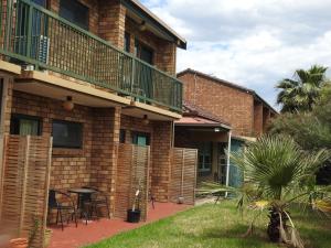 - un bâtiment en briques avec un balcon et une terrasse dans l'établissement Pooraka Motor Inn, à Mawson Lakes