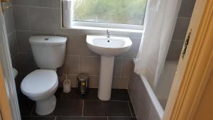 a bathroom with a toilet and a sink and a window at Elegant and spacious 2 bedroom in Barnet +27 photos
