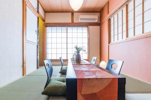 un comedor con una mesa larga y sillas en Bijou Suites Ikoi en Osaka
