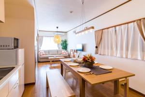 cocina y sala de estar con mesa y sofá en Bijou Suites Ikoi en Osaka
