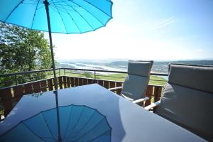 a table with an umbrella and chairs on a balcony at das Rebenhaus in Rüdesheim am Rhein