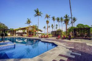 una piscina en un complejo con palmeras en Brits Resort Lovina, en Lovina