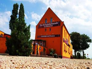 ein orangefarbenes Gebäude mit einem Schild an der Seite in der Unterkunft Landgasthof am Bäumchen in Weißenfels