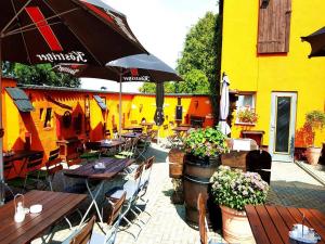 a restaurant with tables and chairs and an umbrella at Landgasthof am Bäumchen in Weißenfels