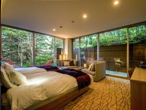 a bedroom with a large bed and a large window at TKP Lectore Hakone Gora in Hakone