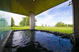 a swimming pool in a house with a large window at The Windsor Hotel TOYA Vignette Collection in Lake Toya