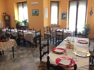Casa dei Nonni في بيانيزا: غرفة طعام مع طاولات وكراسي بمناديل حمراء