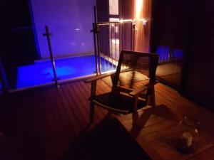a dark room with a wooden chair and a cross at Chandeliers on Abbey in Yallingup