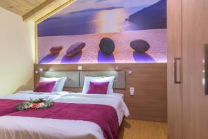 a hotel room with two beds with a painting on the wall at Sofia Apartments in Alexandroupoli