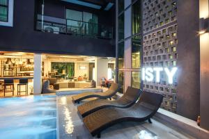 a hotel lobby with two benches and a swimming pool at ISTY Design Hotel in Chiang Mai