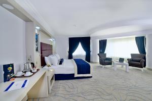 um quarto de hotel com uma cama, uma secretária e cadeiras em New Marathon Hotel em Elazig