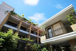 un edificio con balcones y plantas. en Kondra Premiere Guest House Kuta en Kuta