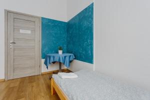 een slaapkamer met een bed en een blauwe muur bij Hostel Tara in Krakau