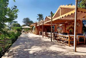 a building with tables and chairs on a street at Hotel Sheherazade Luxor in Luxor