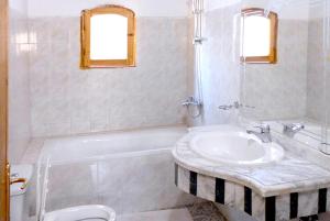 a bathroom with a sink and a tub and a toilet at Hotel Sheherazade Luxor in Luxor