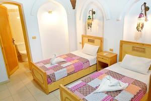 2 łóżka w pokoju z lustrem w obiekcie Hotel Sheherazade Luxor w mieście Luksor