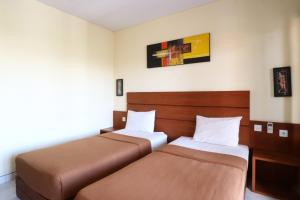 Postel nebo postele na pokoji v ubytování Kondra Premiere Guest House Kuta