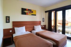 Postel nebo postele na pokoji v ubytování Kondra Premiere Guest House Kuta