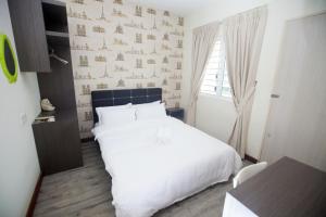 um quarto com uma cama branca e uma parede em Double Storey Linked To KPJ Medical Specialist Centre Bdc 10BR By Natol Homestay-Paris em Kuching