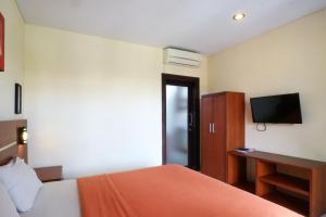 Postel nebo postele na pokoji v ubytování Kondra Premiere Guest House Kuta