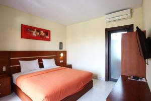 Postel nebo postele na pokoji v ubytování Kondra Premiere Guest House Kuta