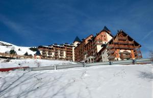 a large building in the snow with snow covered at Résidence Goélia Les Balcons du Soleil in Les Deux Alpes