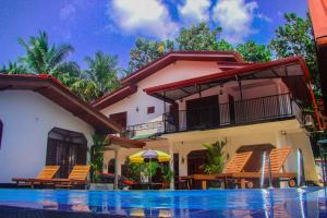 a house with a swimming pool in front of it at Sevonrich Holiday Resort in Dambulla