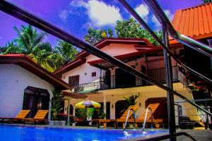 a house with a swimming pool in front of a house at Sevonrich Holiday Resort in Dambulla