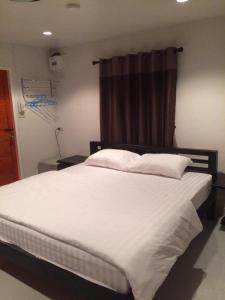 - une chambre avec un grand lit blanc et une fenêtre dans l'établissement Baan Phu Jad Kan, à Uttaradit
