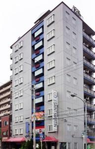 Un alto edificio bianco con un cartello davanti di Saint martin (Adult Only) a Kyoto
