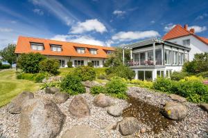 una casa con techo naranja y jardín de rocas en H.W.S. Hotel Der Wilde Schwan en Sagard