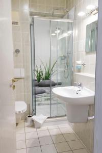 a bathroom with a sink and a glass shower at Hotel Landsberg in Landsberg