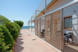 ein Haus mit einem Gehweg am Strand in der Unterkunft Tre Merli Beach Hotel in Triest