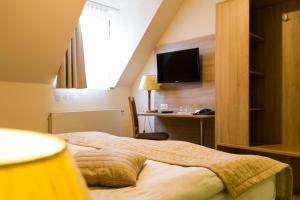 a hotel room with a bed and a desk at Hotel Landsberg in Landsberg