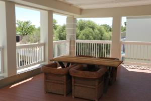 a screened in porch with a wooden table and chairs at Boutique Guesthouse Mariental in Mariental +33 photos