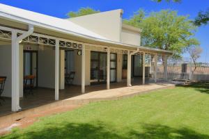 a house with a white roof and a yard at Boutique Guesthouse Mariental in Mariental