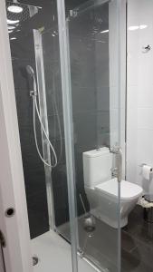 カディスにあるCaletaのバスルーム(トイレ、ガラス張りのシャワー付)