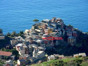 a village on a hill near the ocean with a red house at Terre Apartment in Corniglia