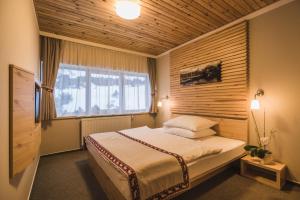 a bedroom with a bed and a large window at Horsky Hotel Sliezsky Dom in Tatranská Polianka