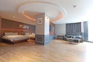 Habitación grande con cama y sofá en Benikea Swiss Rosen Hotel en Gyeongju