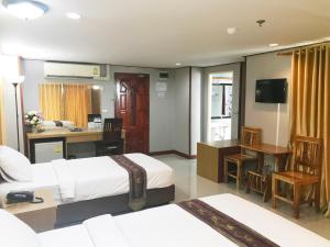 a hotel room with two beds and a desk at Toh Buk Seng Ayutthaya Hotel in Phra Nakhon Si Ayutthaya