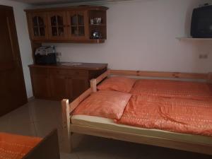 Schlafzimmer mit einem Bett mit orangefarbener Bettwäsche und einem Schreibtisch in der Unterkunft FEWO Plösch vlg. Maierhofer in Lavamünd