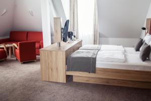 a bedroom with a bed and a red couch at HOTEL SPECHT Tremonia Group - Dortmund in Dortmund +54 photos