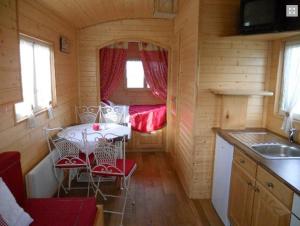 una pequeña cocina con mesa y sillas en una cabaña en La Canfouine en Lamballe