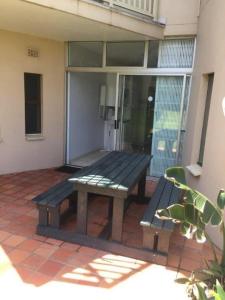 a picnic bench sitting on the patio of a house at Umdloti Cabanas 21 Triplex in Umdloti