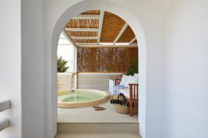 a bathroom with a tub in the middle at Vrahos Boutique Hotel in Karavostasi