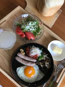 七尾市にある能登島ゲストハウス 葉波の木製トレイの上に盛られた2皿(卵、サラダ付)