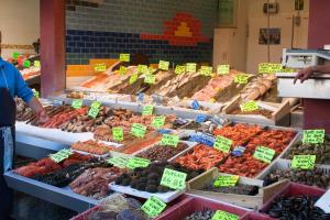 um mercado com muitas frutas e produtos hortícolas diferentes em Les quais de Trouville em Trouville-sur-Mer