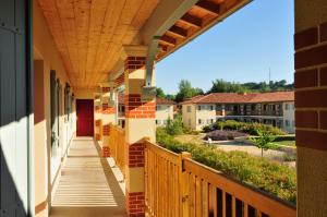 een balkon van een appartementencomplex met een houten veranda bij Résidence Goélia Aquaresort in Nérac
